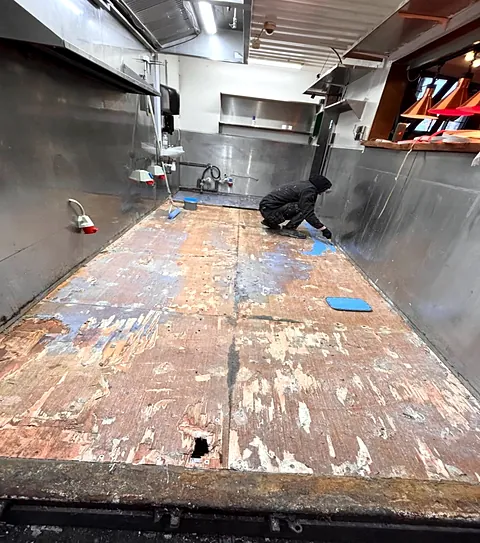 Køkkengulv i foodtruck med slidt og ujævnt undergulv