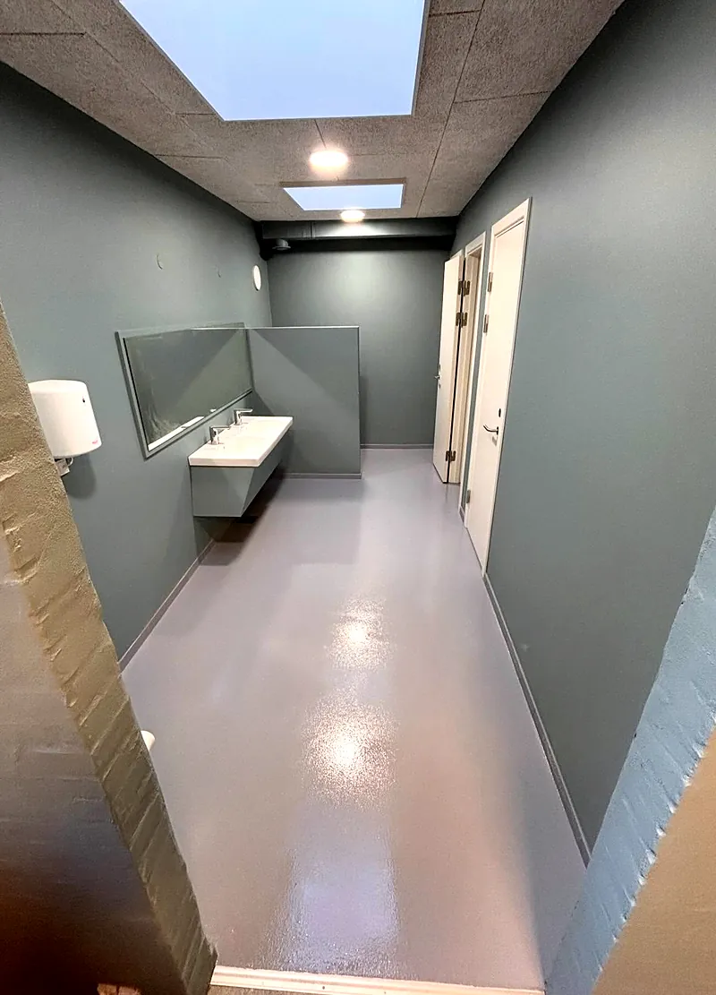 Toiletgang på skole med gråt epoxygulv