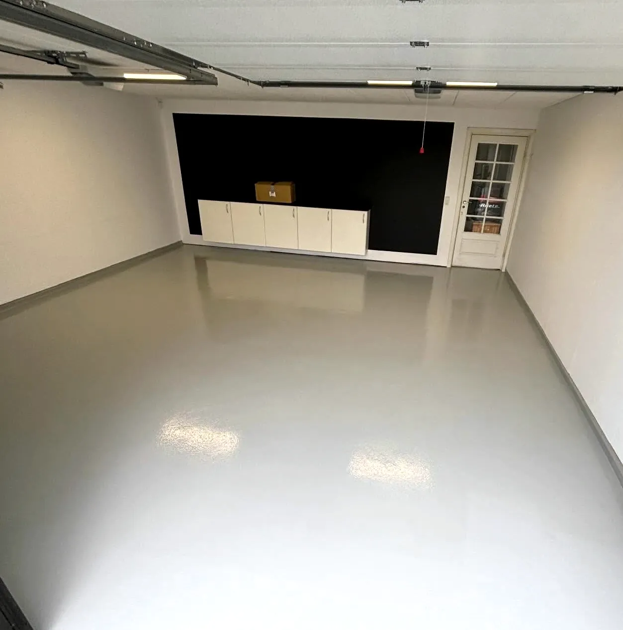 Garage med nyt lysegråt epoxygulv med blank overflade